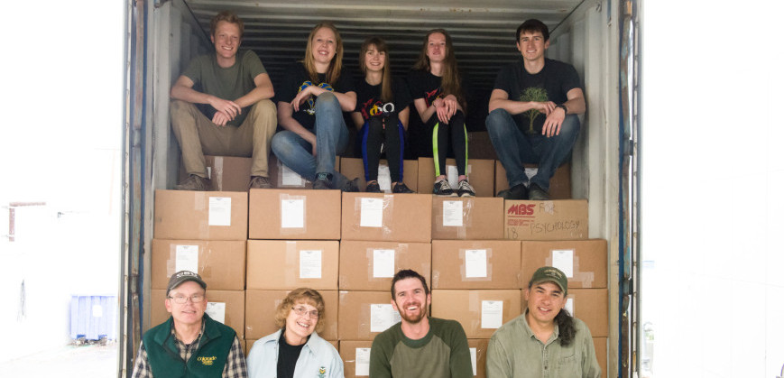 Bob and Nancy Sturtevant (front row left), NREL Research Associate Nicholas Young, and NREL research scientist Paul Evangelista take a break with volunteers from Alpha Phi Omega before they finish filling the shipping container with books for Hawassa University.